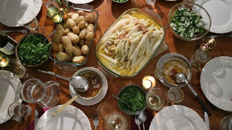 Spargel und anderes Essen auf dem Tisch zubereitet