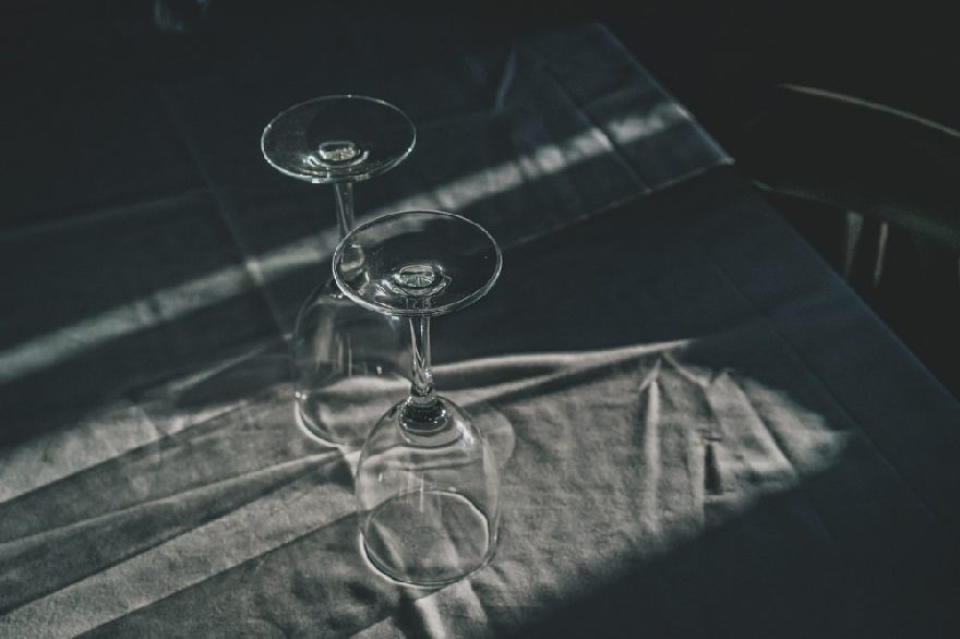 Two wine glasses are on the black table.
